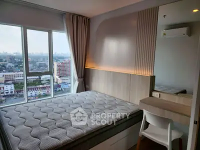 Modern bedroom with city view, featuring a cozy bed and sleek furniture.