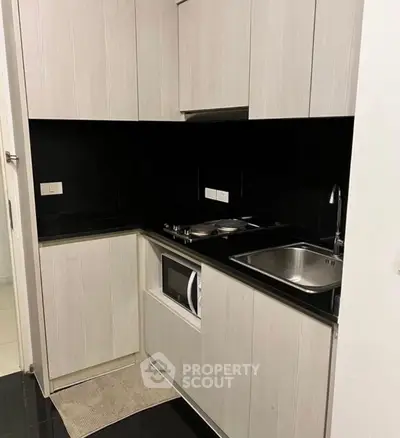 Modern compact kitchen with sleek cabinetry and built-in appliances