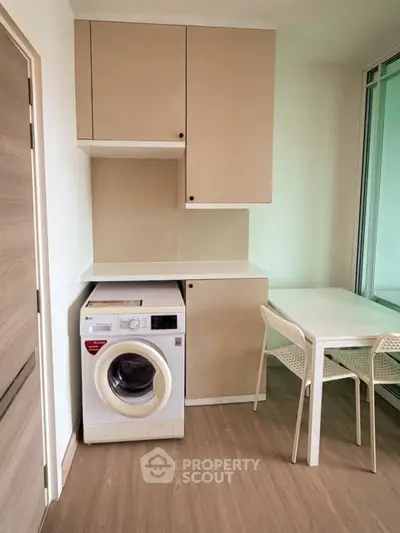 Modern kitchen with washing machine and dining area in stylish apartment