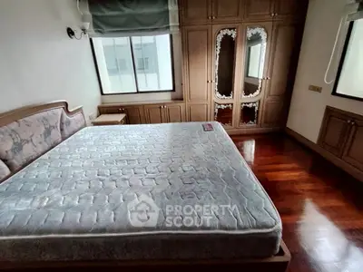 Spacious bedroom with large bed and elegant wooden flooring