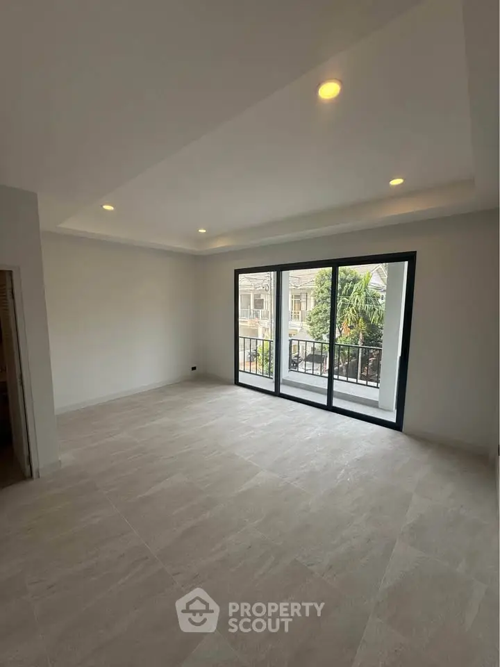 Spacious living room with large windows and balcony access in modern apartment.