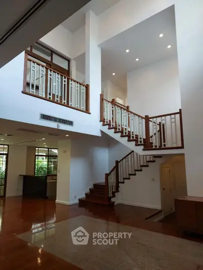 Spacious modern living room with high ceilings and elegant staircase