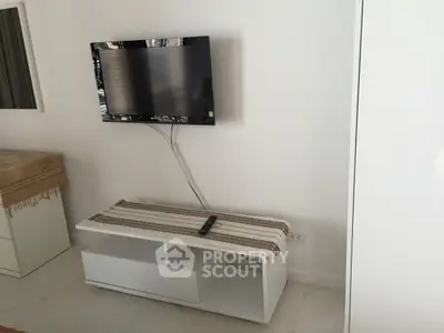 Modern living room with wall-mounted TV and sleek white furniture