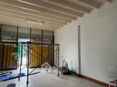Spacious interior under renovation with scaffolding and large windows