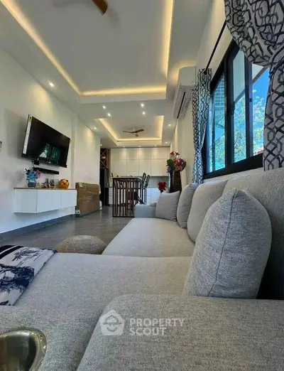 Spacious modern living room with elegant decor and large windows offering natural light.
