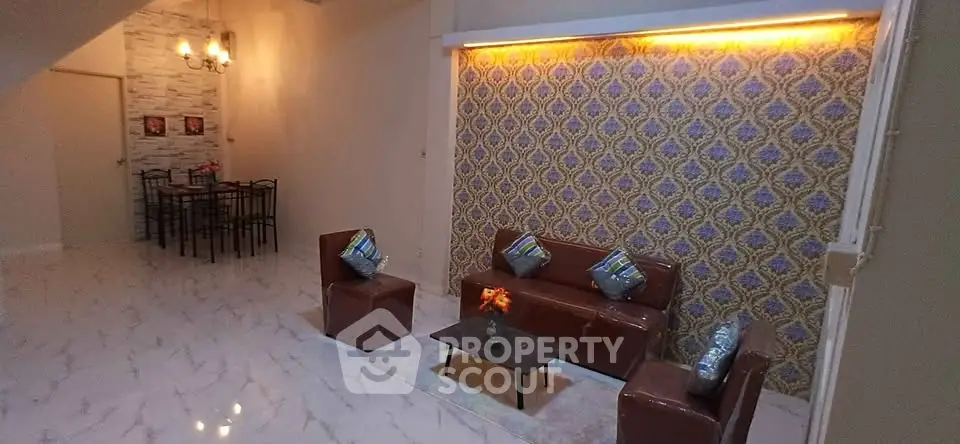 Stylish living room with elegant wallpaper and modern dining area, perfect for entertaining guests.