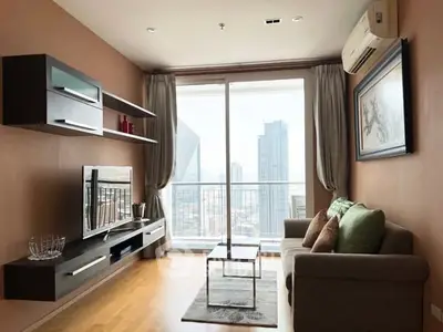 Modern living room with city view, stylish furniture, and natural light.