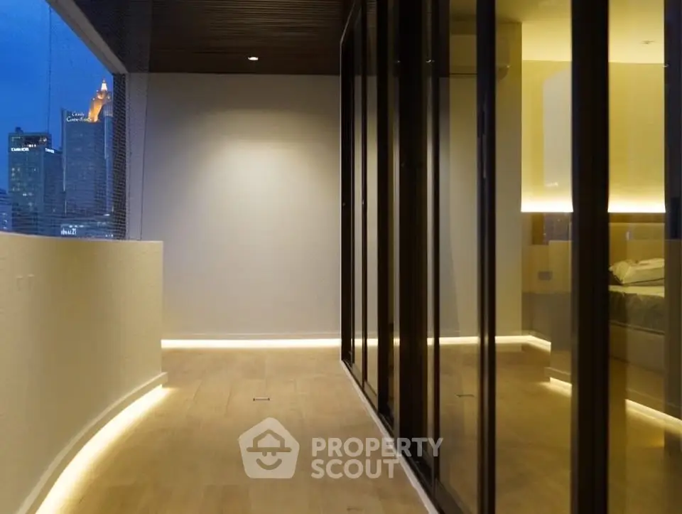 Modern apartment with sleek glass walls and ambient lighting, offering a stunning city view.