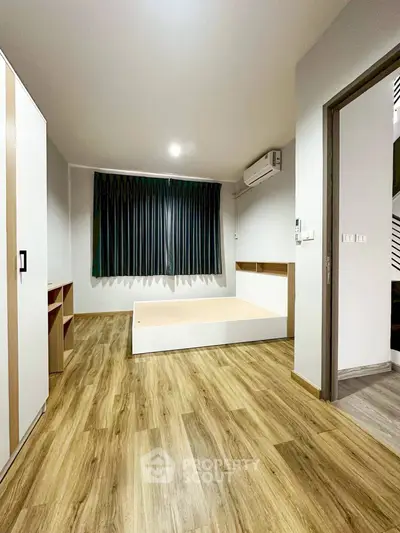 Spacious bedroom with modern wood flooring and built-in storage