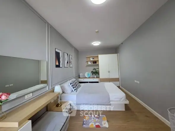 Modern bedroom with stylish decor and ample natural light, featuring a cozy bed and sleek furnishings.