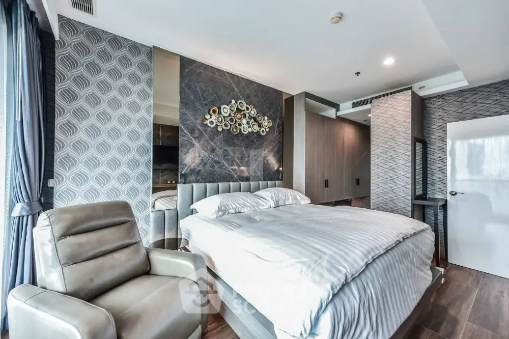 Luxurious modern bedroom with stylish decor and large windows offering natural light and a cozy ambiance.