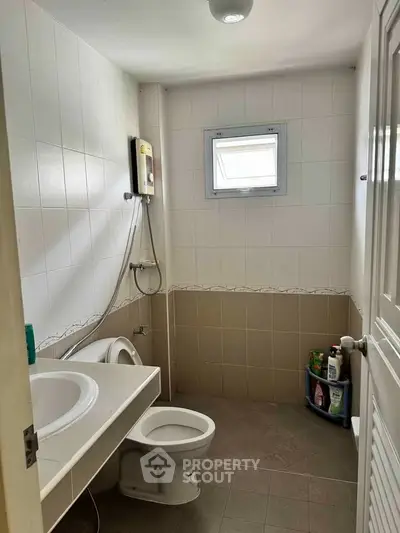 Compact bathroom with modern fixtures and small window for natural light.