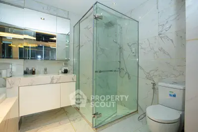Luxurious marble bathroom with glass shower and modern fixtures
