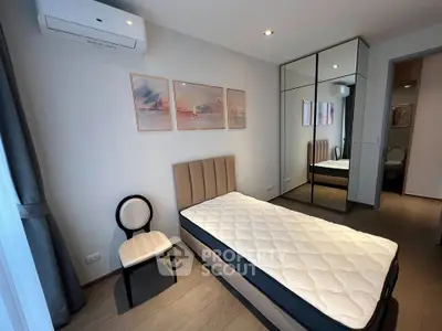 Modern bedroom with single bed, mirrored wardrobe, and stylish decor