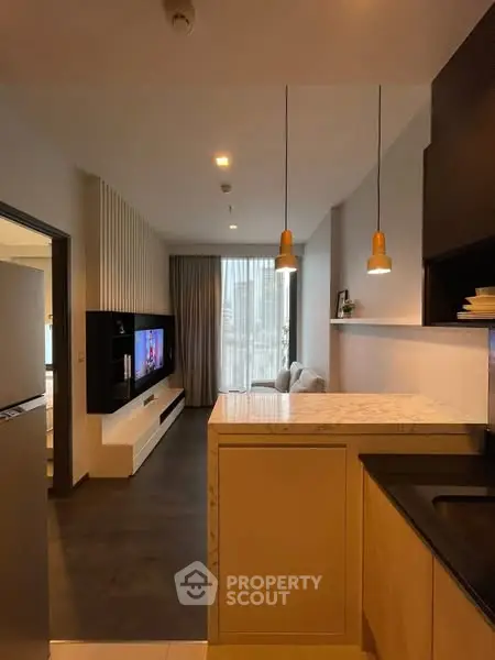 Modern open-plan kitchen and living room with stylish lighting and sleek design.