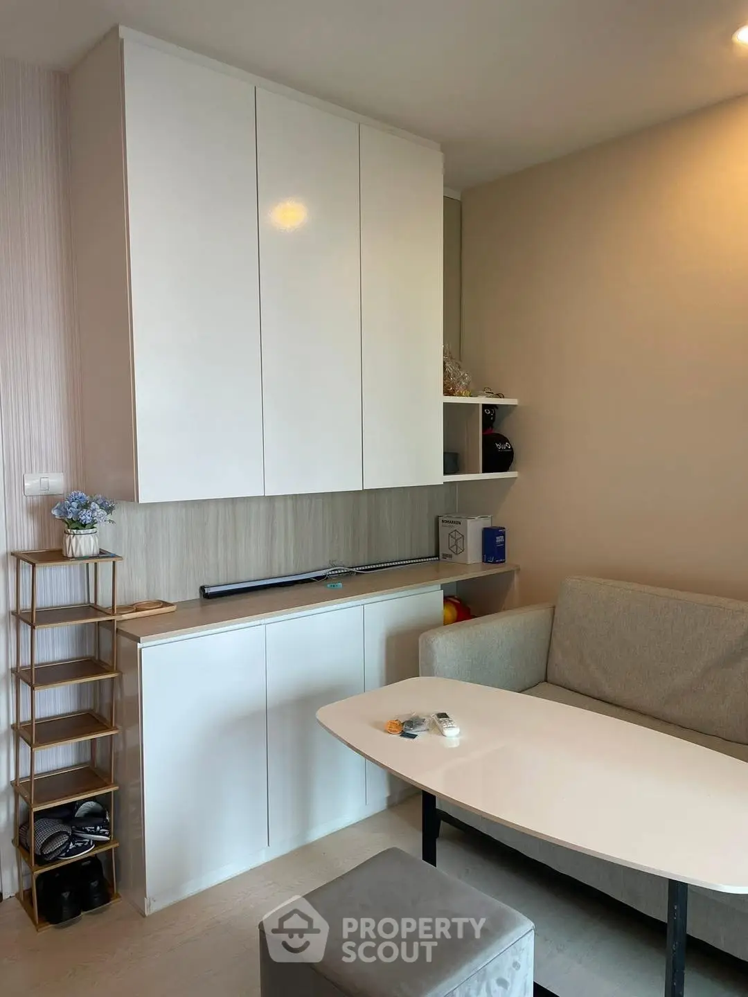 Modern living room with sleek white cabinets and cozy gray sofa