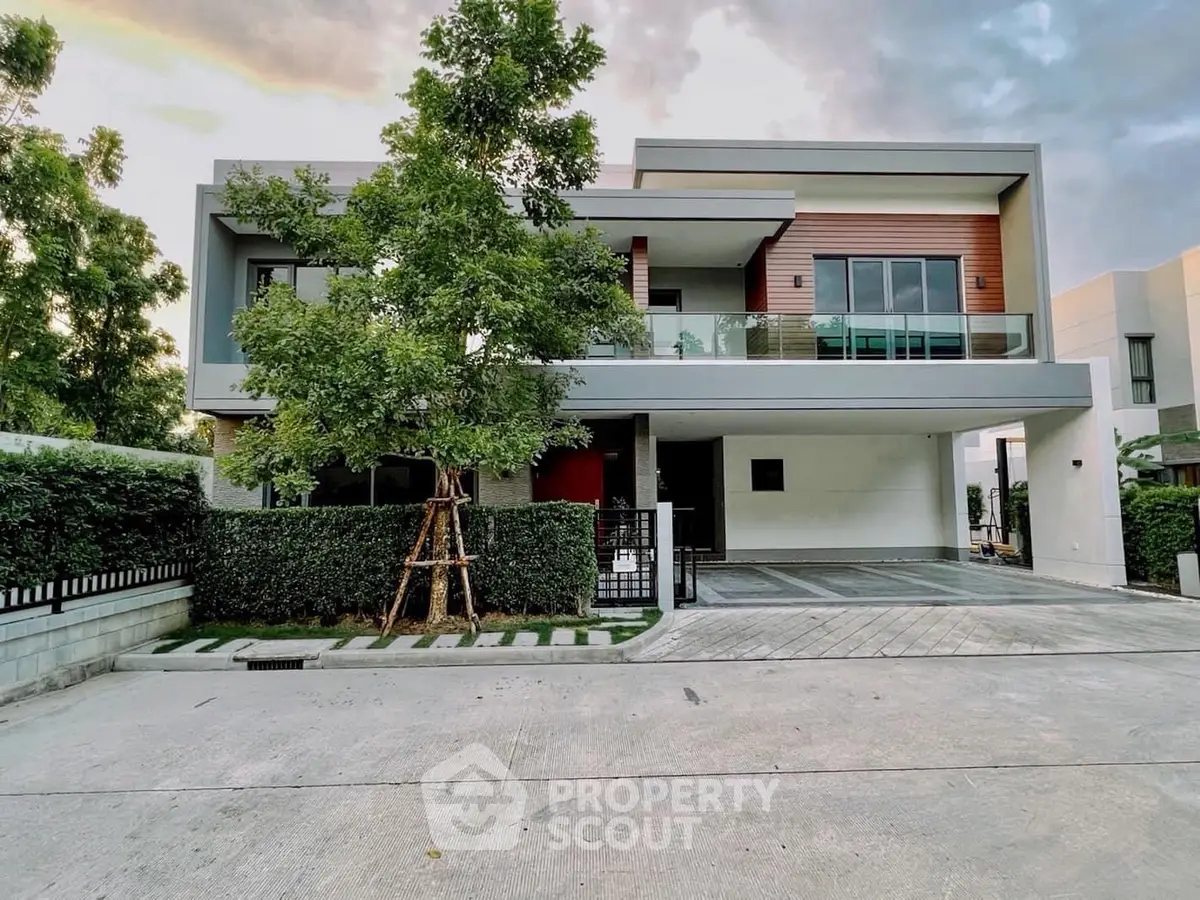 Modern two-story house with sleek design and spacious driveway in a serene neighborhood.