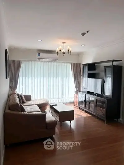 Spacious living room with elegant furniture and natural light in modern apartment.