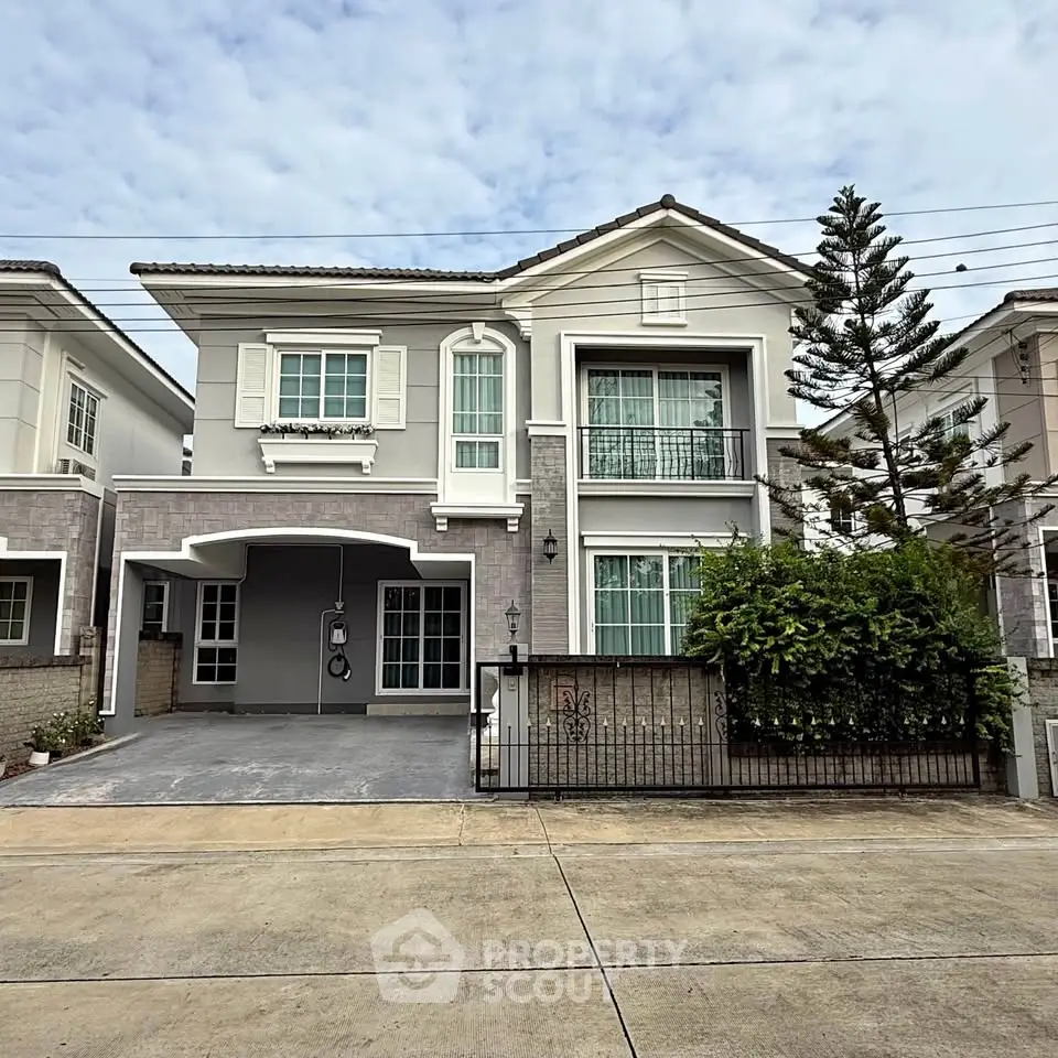 Charming two-story house with modern facade and spacious driveway in a serene neighborhood.