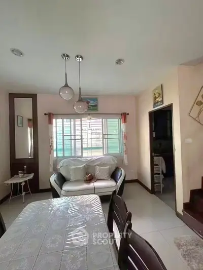 Charming living room with cozy seating and natural light, perfect for relaxation and entertaining.