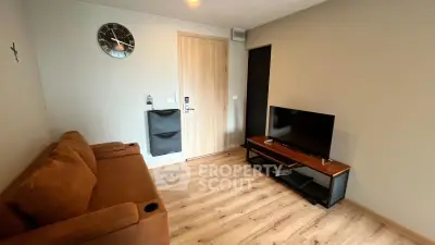 Modern living room with brown sofa, wall clock, and flat-screen TV on wooden floor.