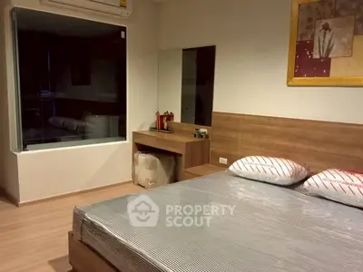Modern bedroom with stylish decor and large mirror, featuring a cozy bed and elegant wooden furniture.