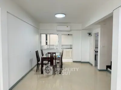Spacious dining area with modern furniture and air conditioning in a bright apartment.