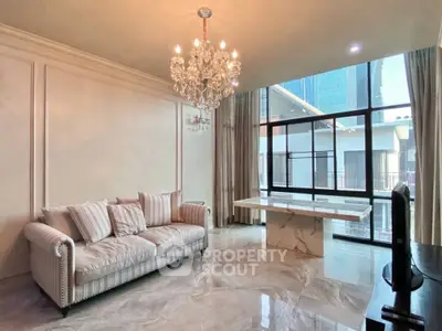Luxurious living room with elegant chandelier and marble flooring in modern apartment.