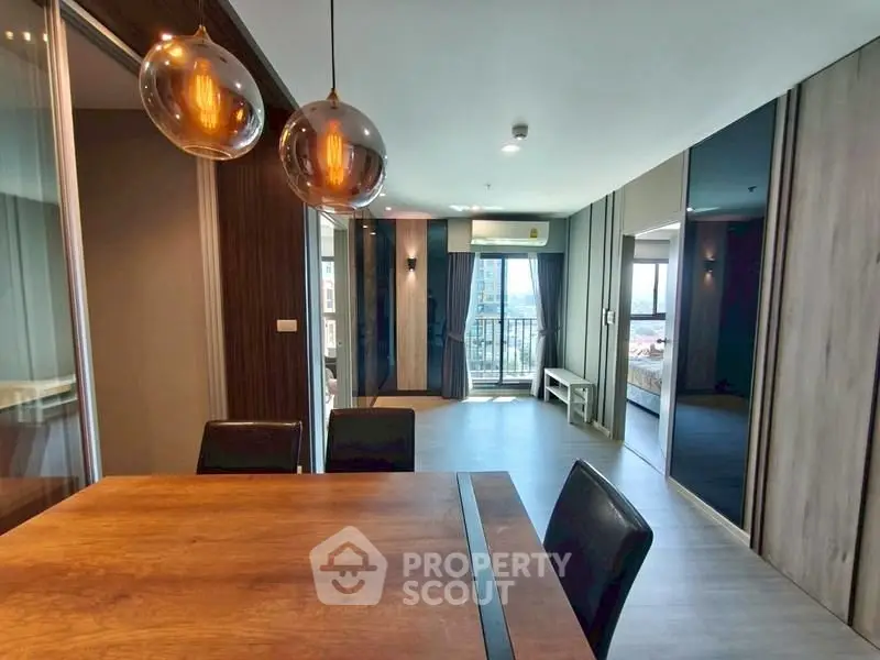 Modern open-plan apartment with stylish dining area and balcony view