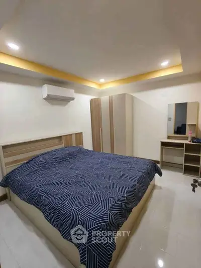 Spacious bedroom with modern design and ample storage in a cozy apartment.