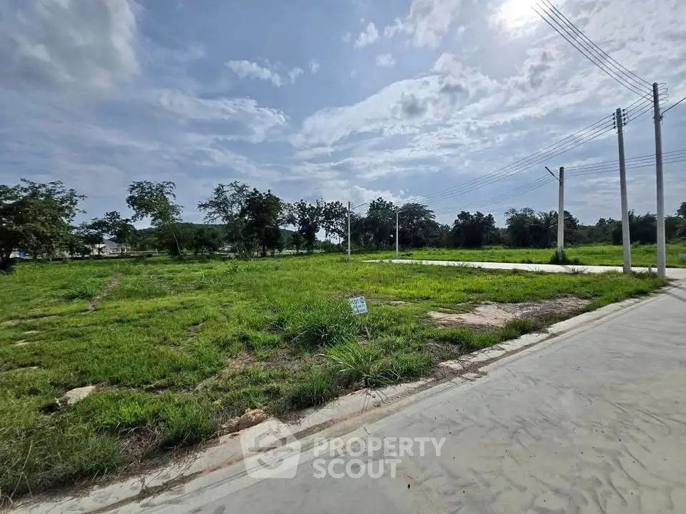 Spacious vacant land plot with lush greenery and clear skies, ideal for development opportunities.
