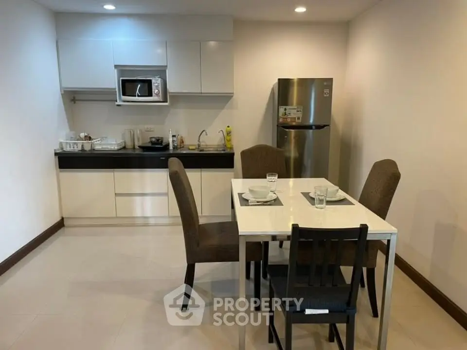 Modern kitchen with dining area featuring sleek appliances and stylish furniture.