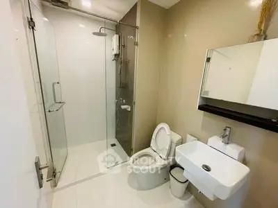 Modern bathroom with glass shower and sleek fixtures in a contemporary apartment.