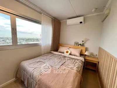 Cozy bedroom with city view, featuring modern decor and air conditioning.