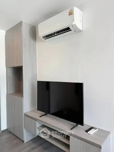 Modern living room with sleek TV setup and air conditioning unit