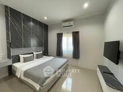 Modern bedroom with sleek design, featuring a comfortable bed, wall-mounted TV, and stylish decor.