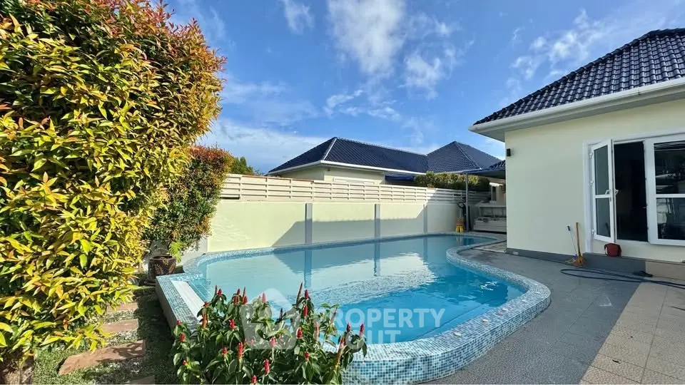 Charming backyard with a sparkling pool and lush greenery, perfect for relaxation and outdoor enjoyment.