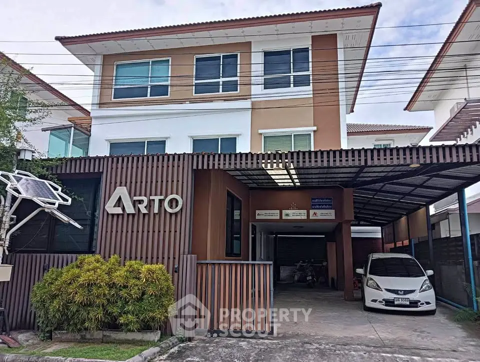 Modern three-story townhouse with carport and solar panel in a suburban neighborhood.