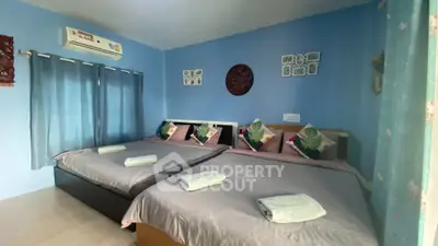 Cozy bedroom with two double beds, air conditioning, and stylish decor in a serene blue setting.