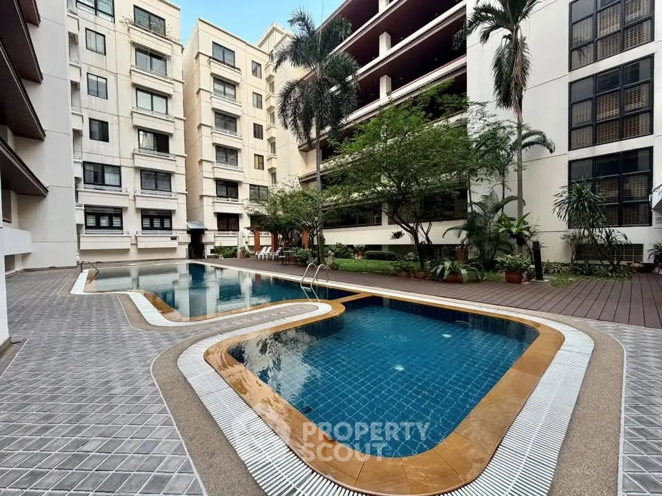Luxurious condominium with a stunning outdoor pool and lush greenery, perfect for relaxation and leisure.