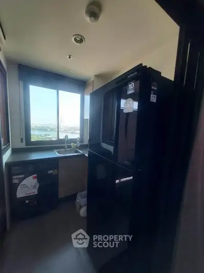 Compact kitchen with modern appliances and city view, ideal for urban living.