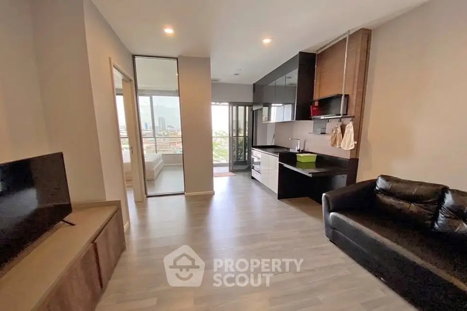 Modern open-plan living room with sleek kitchen and city view