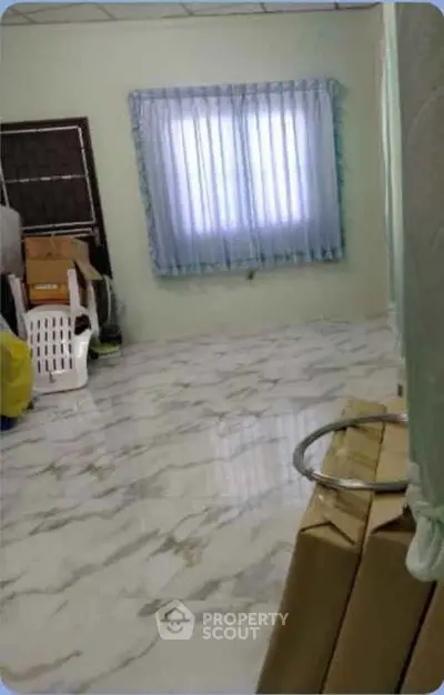 Spacious room with marble flooring and large window, ideal for versatile use.