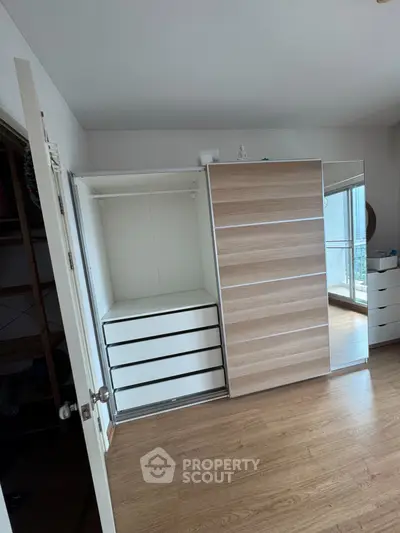 Spacious bedroom with modern wardrobe and wooden flooring, perfect for stylish living.