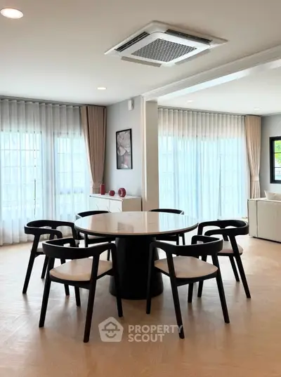 Elegant dining area with modern furniture and large windows in a spacious living room.