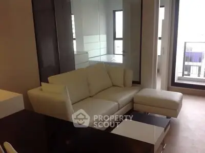 Modern living room with white sofa and large windows offering natural light.