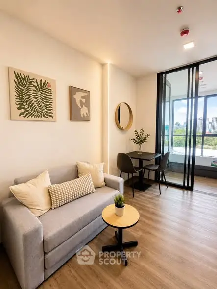 Modern living room with stylish decor and city view, featuring a cozy sofa and dining area.