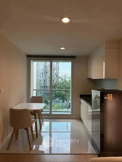 Modern kitchen with dining area and large window offering natural light and city view.