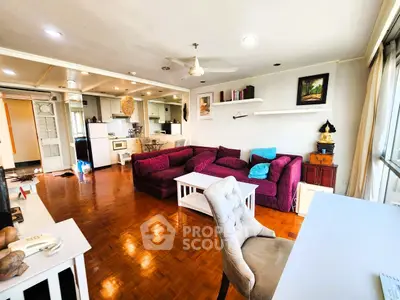 Spacious living room with vibrant purple sofa and open kitchen layout