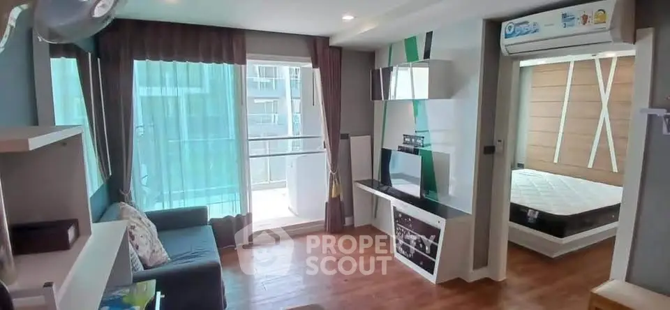 Modern apartment with open living area and bedroom, featuring stylish decor and natural light.